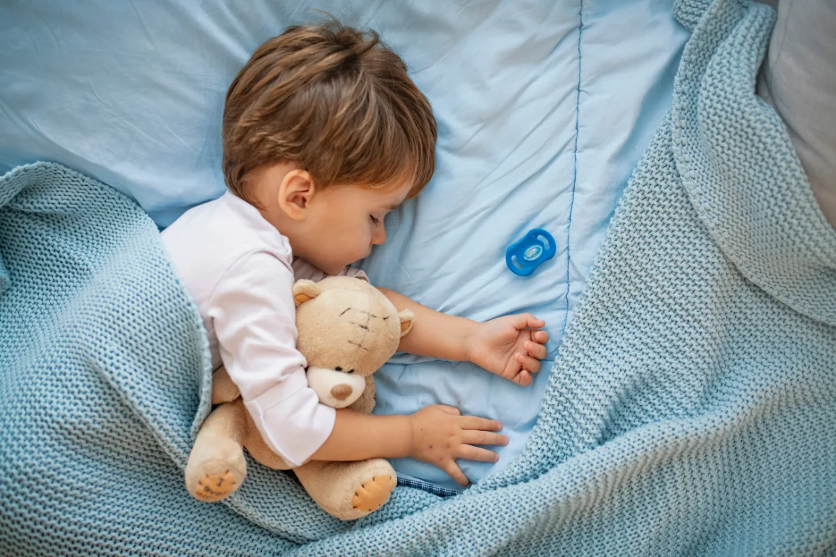 Toddler asleep with a teddy bear